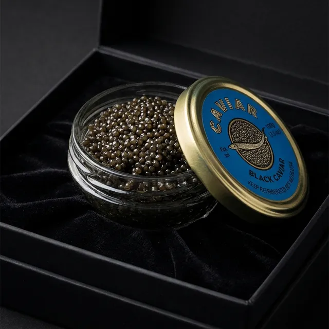 A gold-lidded tin of Kaluga Hybrid caviar on dark slate.